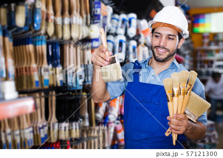 foreman in blue overalls choosing brushes foreman in blue overalls choosing brushes 57121300