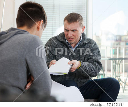 Father scolding son for poor school assignment 57122114
