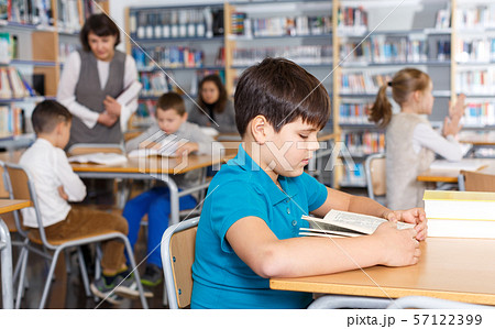 Boy reading in school library Boy reading in school library 57122399