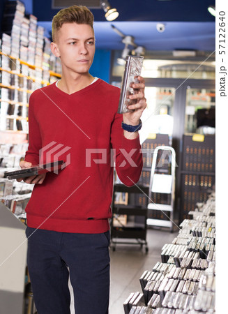 guy looking on box of DVD movie guy looking on box of DVD movie 57122640
