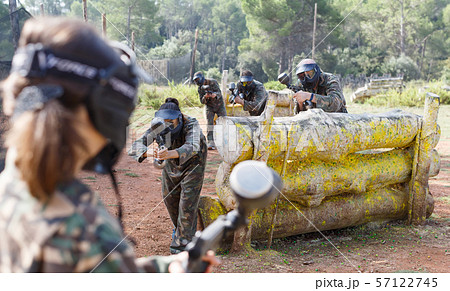 Group of opposite paintball players in camouflage with guns playing in battle Group of opposite paintball players in camouflage with guns playing in battle 57122745