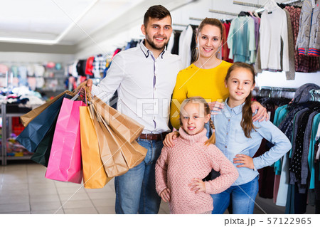 Portrait of happy young woman, two little girls and man with shopping bags in mall Portrait of happy young woman, two little girls and man with shopping bags in mall 57122965