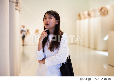 Thoughtful chinese girl in museum looking at antiquity art object 57123046