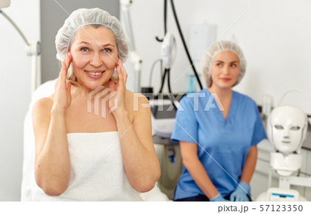 Smiling mature female patient satisfied with received cosmetological procedure in esthetic clinic Smiling mature female patient satisfied with received cosmetological procedure in esthetic clinic 57123350