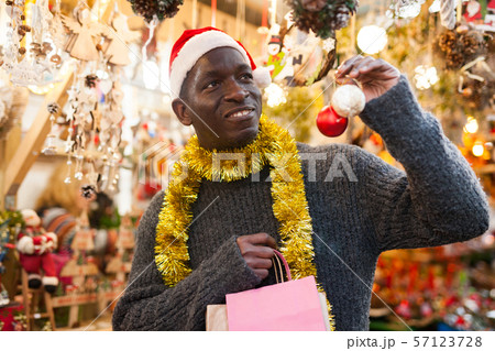 Man in Santa hat looking for New Year decorations Man in Santa hat looking for New Year decorations 57123728