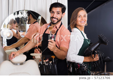 Smiling male makeup artist and woman hairdresser 57123766