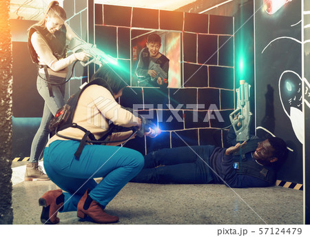 Modern people of different nationalities with laser pistols play Modern people of different nationalities with laser pistols play 57124479