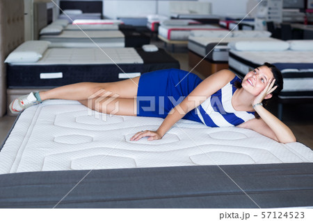 glad woman is lying on bed and testing mattress for relax glad woman is lying on bed and testing mattress for relax 57124523