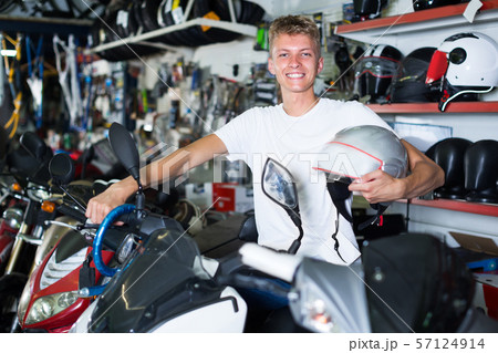 Man is sitting on the motorbike with helmet 57124914