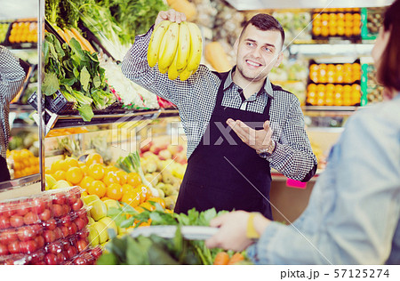 Male seller assisting in buying 57125274