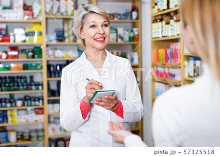 Mature female seller suggesting care products to young customer Mature female seller suggesting care products to young customer 57125518