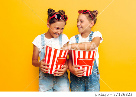 Two teenage girls, girlfriends with popcorn in Two teenage girls, girlfriends with popcorn in 57126822