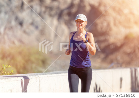 Slim woman in blue top running in the morning. Slim woman in blue top running in the morning. 57126910