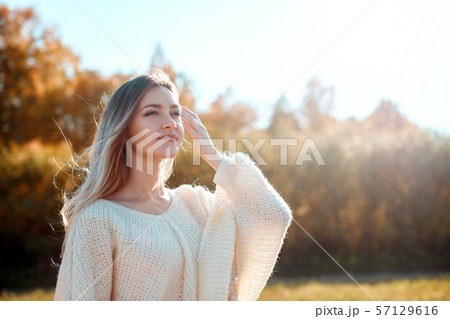 Pretty girl posing on camera and enjoying sunny autumn day. Pretty girl posing on camera and enjoying sunny autumn day. 57129616