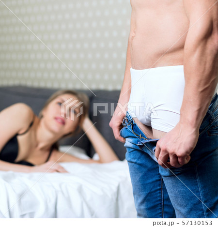 Woman waiting her boyfriend when he takes off his jeans. Woman waiting her boyfriend when he takes off his jeans. 57130153