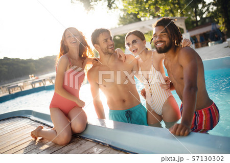 Strong boyfriends hugging their women while chilling in pool Strong boyfriends hugging their women while chilling in pool 57130302