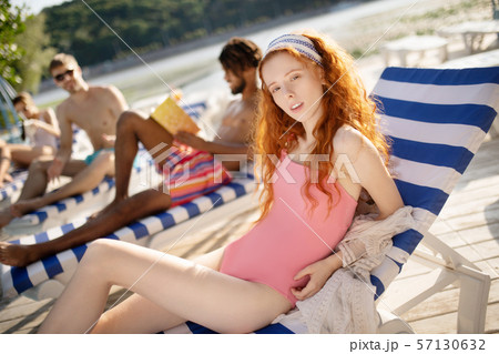 Woman wearing pink swimsuit lying and sunbathing 57130632