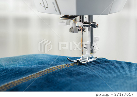 Sewing denim jeans with sewing machine. Close up. 57137017