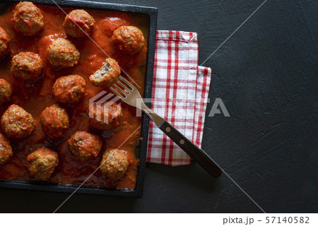 Meatballs in tomato sauce on black tray. Above Meatballs in tomato sauce on black tray. Above 57140582