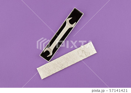 Happy Fathers Day flat lay. Wrench in gift box on purple background Happy Fathers Day flat lay. Wrench in gift box on purple background 57141421