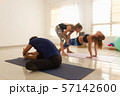 Yoga teacher assisting young girl in purvottanasana. Woman in upward plank pose in bright studio. Asana adjustment, sitting postures, exercise, workout class, healthy lifestyle concepts 57142600