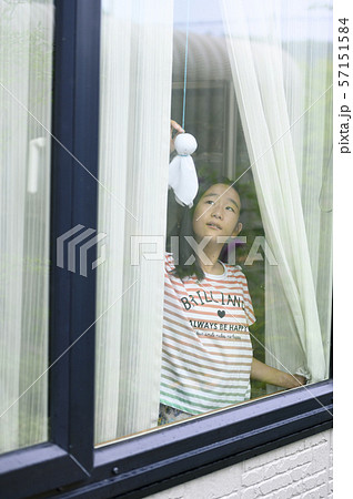 窓から雨の様子を見る子ども（降り止む） 57151584