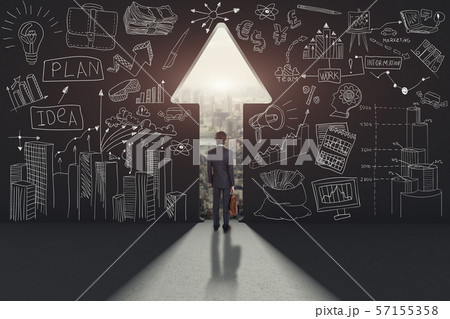 Rear view of a businessman against black wall with an arrow path 57155358