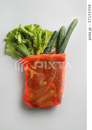Shopping net bag with greens and vegetables. 57155456