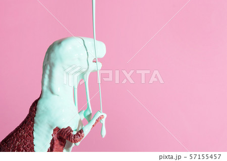 Neo mint paint is pouring on dinosaur toy. Neo mint paint is pouring on dinosaur toy. 57155457