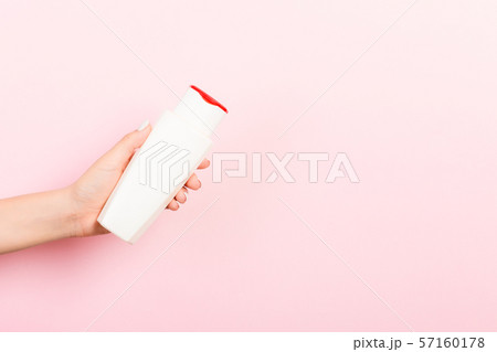 Female hand holding cream bottle of lotion 57160178