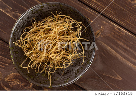 Raw thin noodles on brown wood Raw thin noodles on brown wood 57163319