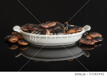 Stained purple bean isolated on black glass 57163442