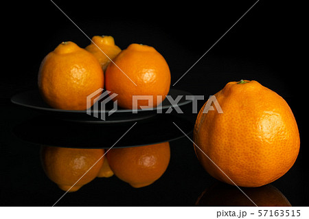 Orange minneola tangelo isolated on black glass Orange minneola tangelo isolated on black glass 57163515