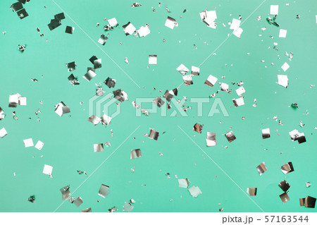 Falling silver confetti on mint backdrop. Falling silver confetti on mint backdrop. 57163544