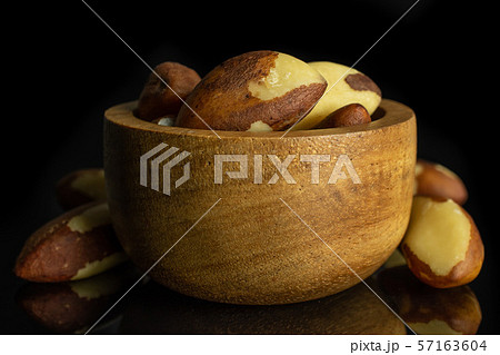 Raw brazil nut isolated on black glass Raw brazil nut isolated on black glass 57163604