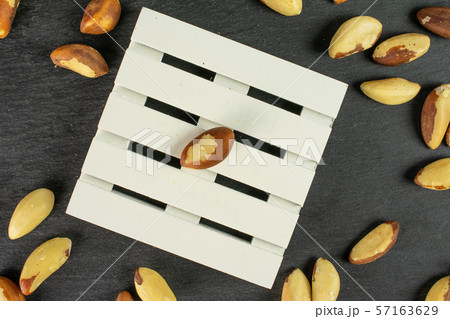 Raw brazil nut on grey stone Raw brazil nut on grey stone 57163629