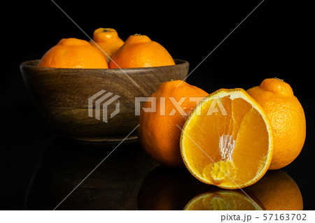 Orange minneola tangelo isolated on black glass Orange minneola tangelo isolated on black glass 57163702