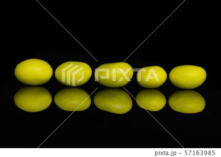 Sugared nut dragee isolated on black glass Sugared nut dragee isolated on black glass 57163985
