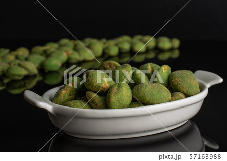 Green wasabi peanut isolated on black glass Green wasabi peanut isolated on black glass 57163988