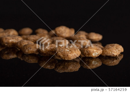 Choco balls cereal isolated on black glass Choco balls cereal isolated on black glass 57164259