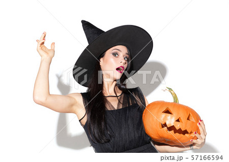 Young woman in hat and dress as a witch on white background Young woman in hat and dress as a witch on white background 57166594