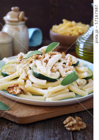 Italian penne pasta with roasted zucchini, grated parmesan cheese and walnuts 57167987
