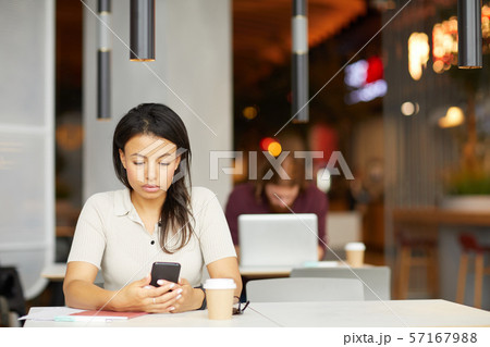 Woman with phone in cafe 57167988
