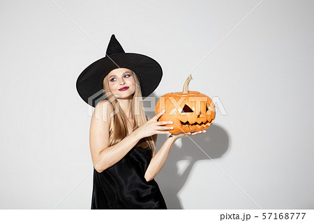Young woman in hat as a witch on white background Young woman in hat as a witch on white background 57168777