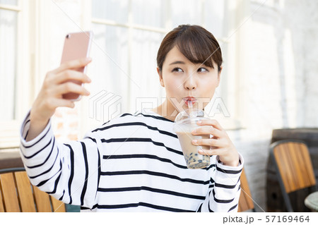タピオカミルクティーを飲んでいる若い女性 タピオカミルクティーを飲んでいる若い女性 57169464