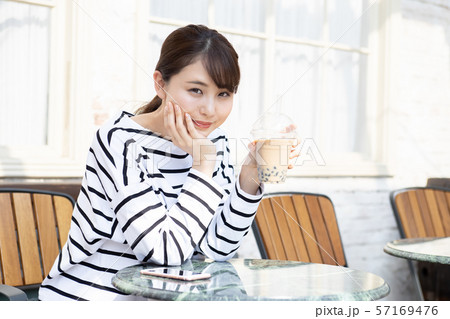 タピオカミルクティーを飲んでいる若い女性 タピオカミルクティーを飲んでいる若い女性 57169476