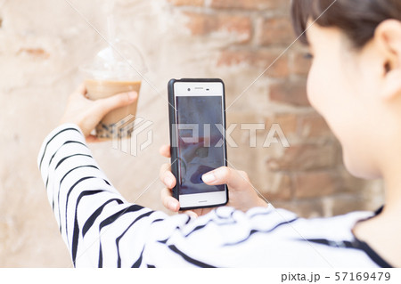 タピオカミルクティーを飲んでいる若い女性 57169479