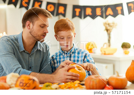 Boy carving pumpkin with father Boy carving pumpkin with father 57171154