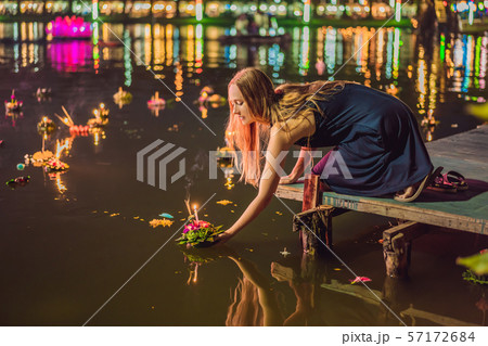 A female tourist holds the Loy Krathong in her hands and is about to launch it into the water. Loy A female tourist holds the Loy Krathong in her hands and is about to launch it into the water. Loy 57172684