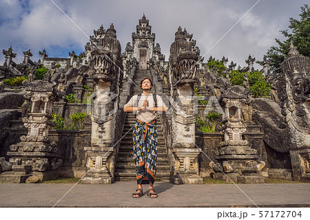 Young man tourist on background ofThree stone ladders in beautiful Pura Lempuyang Luhur temple Young man tourist on background ofThree stone ladders in beautiful Pura Lempuyang Luhur temple 57172704